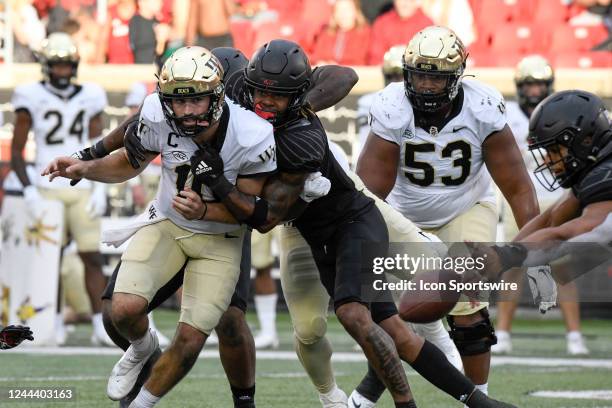 The ball comes loose as Louisville Cardinals defensive back Benjamin Perry gets a hand on Wake Forest Demon Deacons quarterback Sam Hartman during...