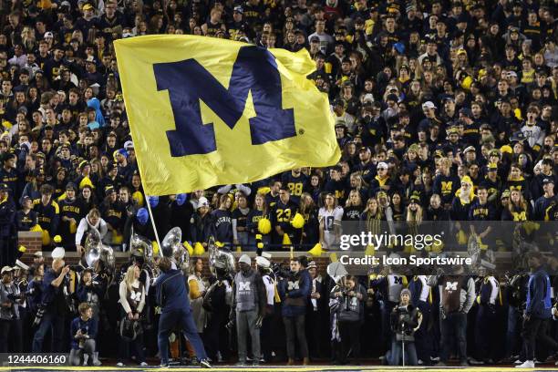 Michigan cheerleader waves a large flag with the Michigan logo on it during a college football game between the Michigan State Spartans and the...