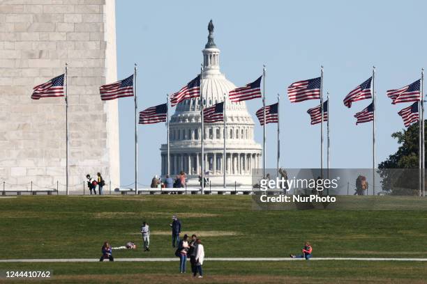The Capitol building is seen through the American flags in Washington DC on October 20, 2022.
