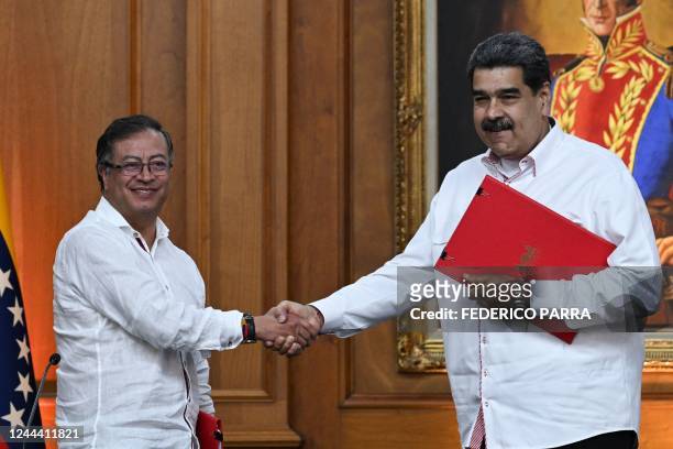 Colombian President Gustavo Petro and his Venezuelan counterpart Nicolas Maduro shake hands after signing agreements at Miraflores Presidential...