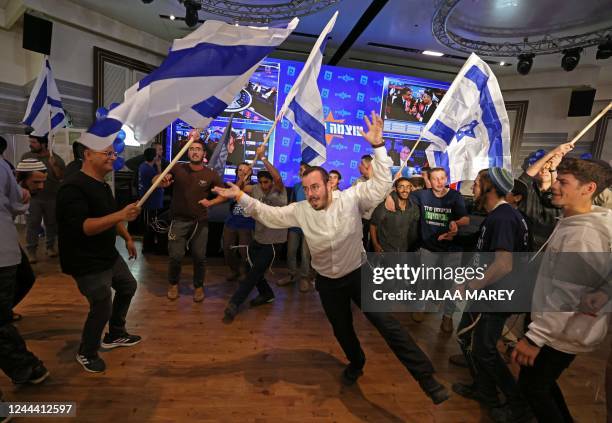 Supporters of Israel's Otzma Yehudit far-right party react at campaign headquarters in Jerusalem on November 1 after the end of voting for national...
