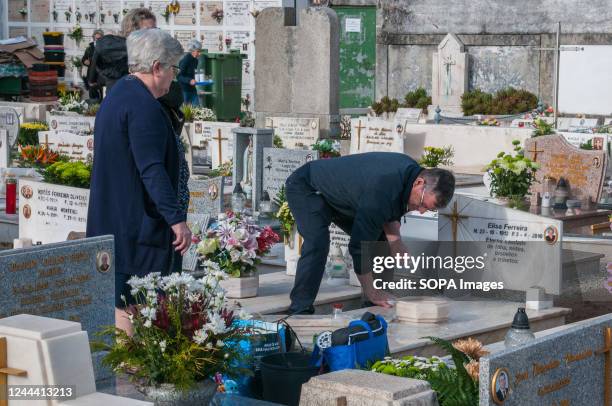 Man cleans the family gravestone during the All Saints' Day in Lordelo do Ouro Cemetery. November 1st, families remember their deceased loved ones. A...