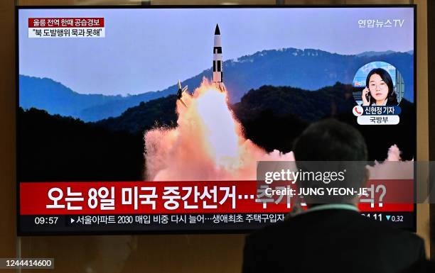 Man watches a television screen showing a news broadcast with file footage of a North Korean missile test, at a railway station in Seoul on November...