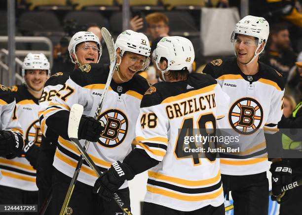 Hampus Lindholm of the Boston Bruins celebrates with Matt Grzelcyk after scoring the game winning goal in overtime giving the Bruins a 6-5 win over...