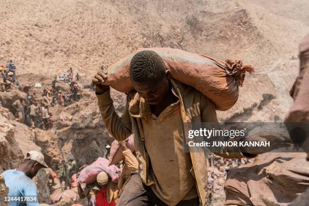 An artisanal miner carries a sack of ore at the Shabara artisanal mine near Kolwezi on October 12, 2022. - Some 20,000 people work at Shabara, in...