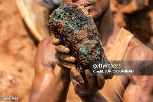 Dela wa Monga, an artisanal miner, holds a cobalt stone at the Shabara artisanal mine near Kolwezi on October 12, 2022. - Some 20,000 people work at...