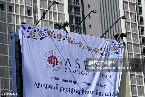 Workers unfold a banner for the upcoming ASEAN summit in Phnom Penh on November 2, 2022.