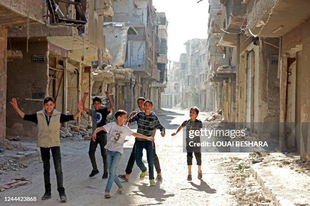 Boys play amid destroyed buildings at the Yarmuk refugee camp in the southern suburbs of the Syrian capital Damascus on November 2, 2022. - The...