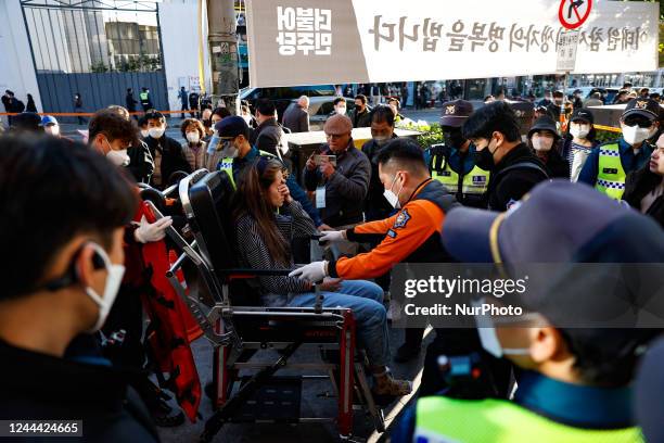 Rescue teams transport a fainted woman to the hospital on Itaewon street near to the the Halloween celebration stampede scene on November 02, 2022 in...