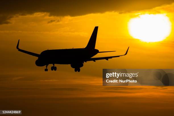 Aircraft silhouette, a symbol illustration photo during the magic hour of an arriving passenger plane for landing at Eindhoven Airport. Dusk and...