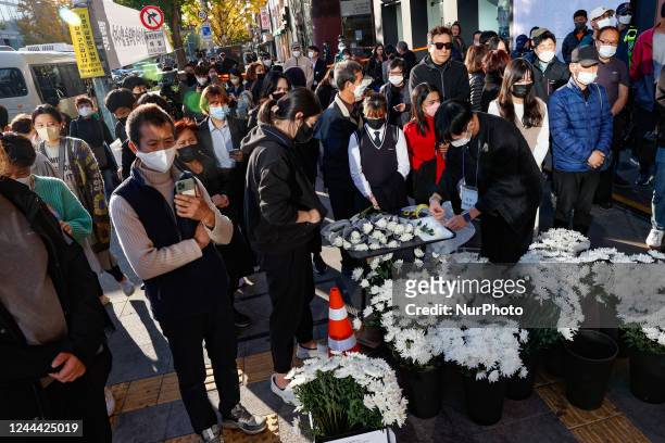 Volunteers prepare free flowers during the pay tribute to the victims of the Halloween celebration stampede, on Itaewon street near to the scene on...