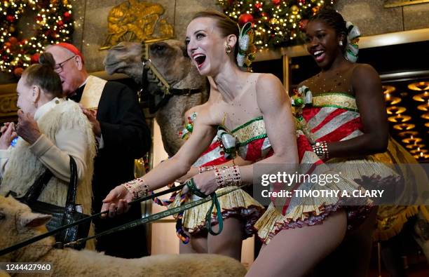 The Archbishop of New York, Cardinal Timothy Dolan, joins Radio City Rockettes Karen Ritchie and Jojo Carmichael during the blessing of the animals...