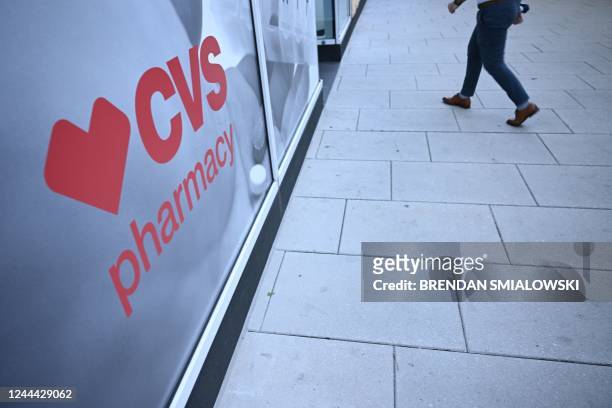 Pedestrian walks into a CVS Pharmacy in Washington, DC, on November 2, 2022. CVS Health said they had agreed to pay approximately $5 billion over 10...