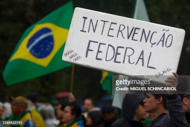 Supporter of Brazilian President Jair Bolsonaro takes part in a protest to ask for federal intervention outside Brazil's Armed Forces Headquarters in...