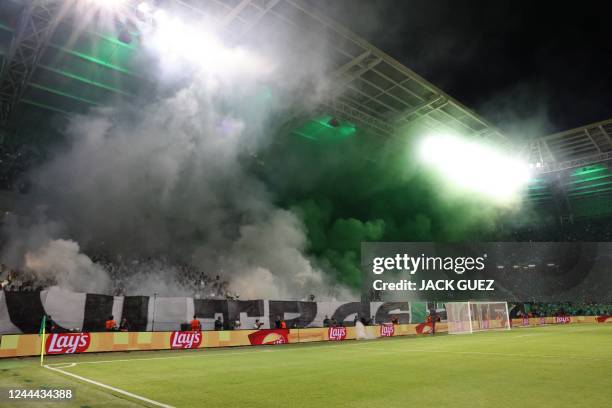 Fans light flares during the UEFA Champions League group H football match between Israel's Maccabi Haifa and Portugal's Benfica at the Sammy Ofer...