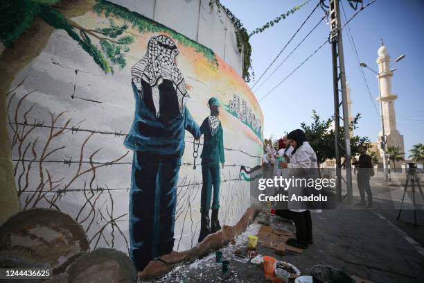 Palestinian artists draw pictures on the wall, describing the right of Palestinians to return to their homeland, on the 105th anniversary of the...