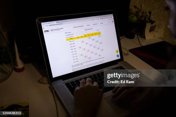 Woman checks the schedule for planned power cuts in her area on energy company DTEKs website November 02, 2022 in Kyiv, Ukraine. Electricity and...