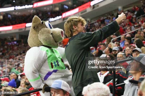 Fan takes a photo with Stormy during the game between the Washington Capitals and the Carolina Hurricanes on October 2022 at PNC Arena in Raleigh, NC.