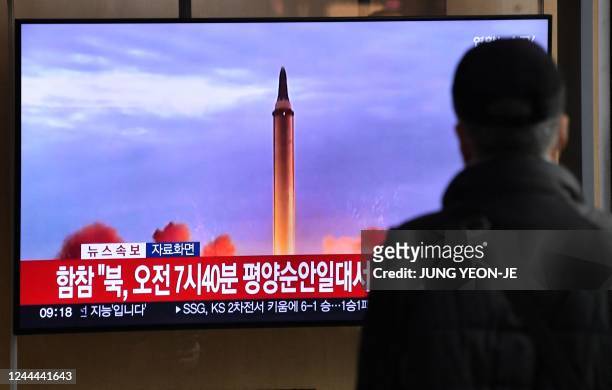 Man watches a television screen showing a news broadcast with file footage of a North Korean missile test, at a railway station in Seoul on November...