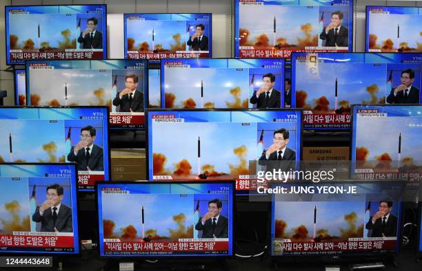 Television screens show a news report about the latest North Korean missile launch with file footage of a North Korean missile test, at an electronic...