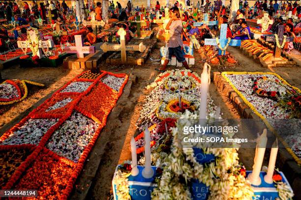 Graves are well-decorated with flowers and candles during All Souls' Day. Christian devotees gather at the graves of their departed loved ones at a...