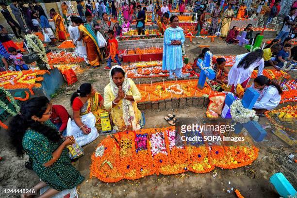 Christian family members pay respect and offer prayers beside their relative's graves during All Souls' Day. Christian devotees gather at the graves...