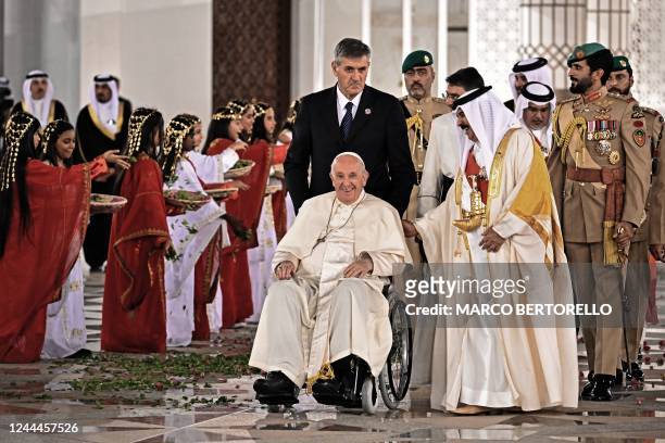 Pope Francis is escorted by Bahrain's King Hamad bin Isa al-Khalifa as he leaves the Sakhir Palace in the city of Sakhir on November 3, 2022.
