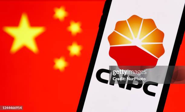 China National Petroleum Corporation logo displayed on a phone screen and Chinese flag displayed on a screen in the background are seen in this...