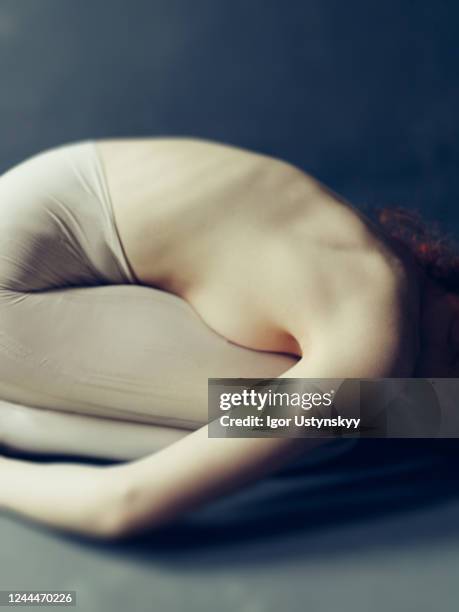 woman curled up in the fetal position - foetushouding stockfoto's en -beelden