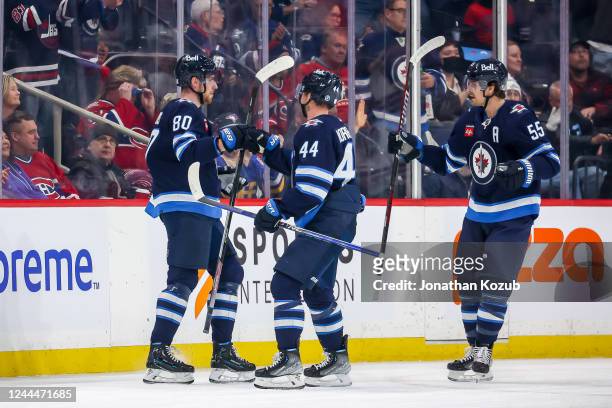 Pierre-Luc Dubois, Josh Morrissey and Mark Scheifele of the Winnipeg Jets celebrate a first period goal against the Montreal Canadiens at the Canada...