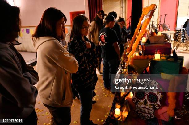 Ilene Vargas , center and her friend are watching an altar for Dia de los Muertos event at Aurora West College Preparatory School in Aurora, Colorado...