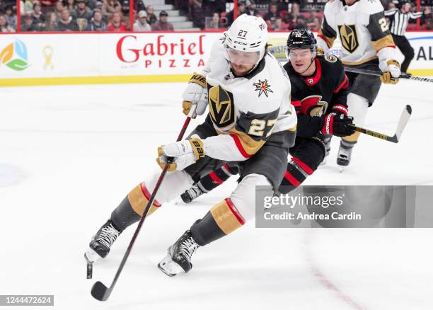 Shea Theodore of the Vegas Golden Knights controls the puck against Alex DeBrincat of the Ottawa Senators at Canadian Tire Centre on November 3, 2022...