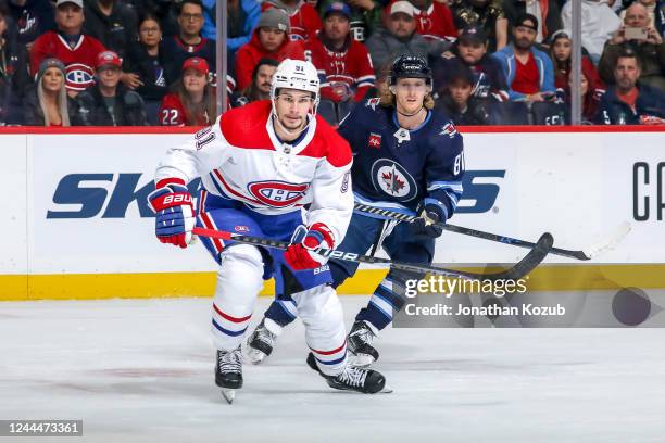 Sean Monahan of the Montreal Canadiens and Kyle Connor of the Winnipeg Jets keep an eye on the play during second period action at the Canada Life...