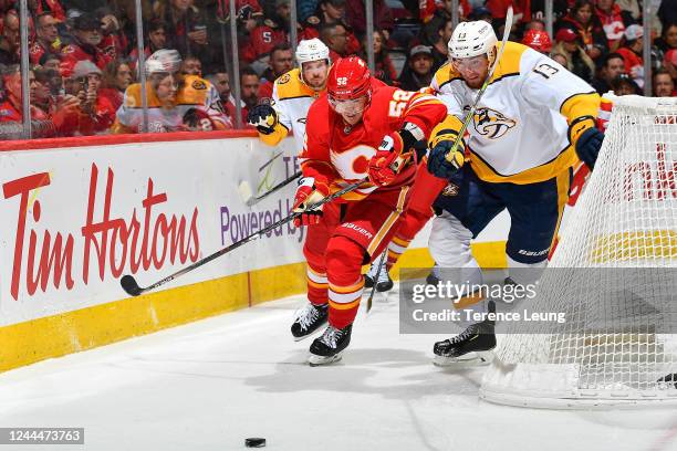 MacKenzie Weegar of the Calgary Flames battles against Yakov Trenin of the Nashville Predators at Scotiabank Saddledome on November 3, 2022 in...