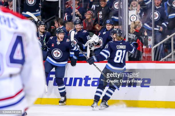 Dominic Toninato of the Winnipeg Jets leaps off the bench to celebrate the overtime winning goal against the Montreal Canadiens with teammate Kyle...
