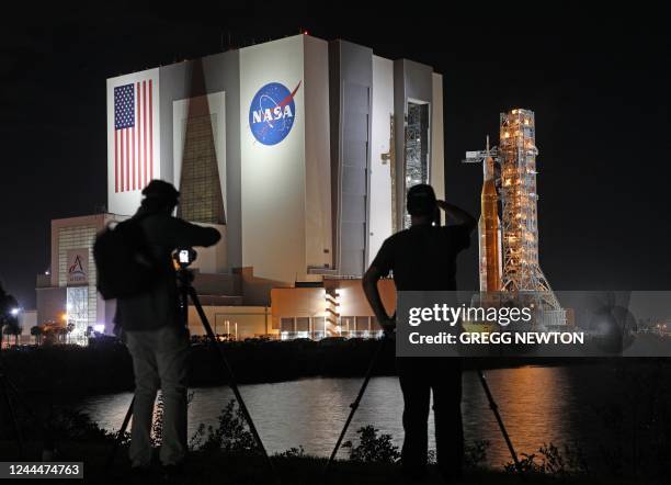 Photographers record the Artemis-1 rocket as it rolls out from the Vehicle Assembly Building en route to Launch Pad 39B shortly after midnight at the...