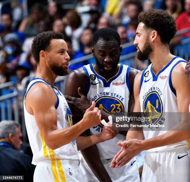 Stephen Curry of the Golden State Warriors, Klay Thompson, and Draymond Green stand on the court during the game against the Orlando Magic on...