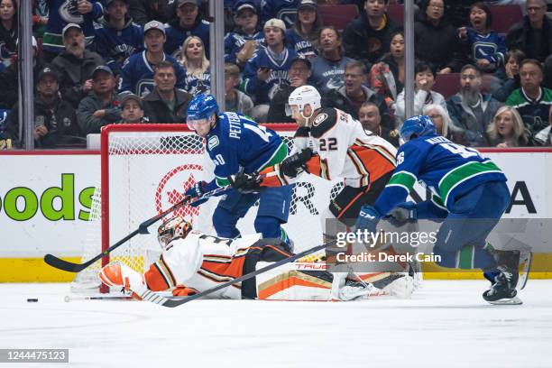 Elias Pettersson of the Vancouver Canucks and John Gibson of the Anaheim Ducks reach for the puck during the third period of their NHL game at Rogers...