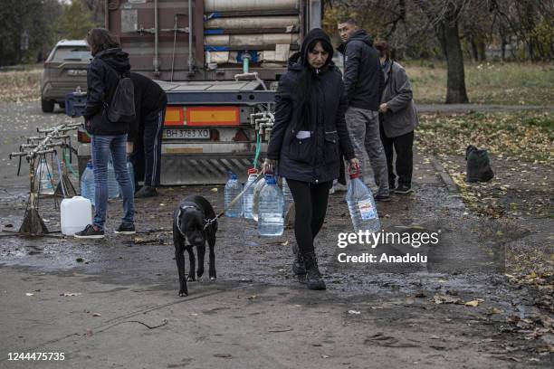 Ukrainian citizens carry bottles and buckets to receive clean water as Russia-Ukraine war continue in Mykolaiv, Ukraine on November 03, 2022. Water...