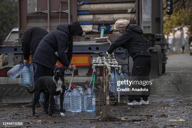 Ukrainian citizens carry bottles and buckets to receive clean water as Russia-Ukraine war continue in Mykolaiv, Ukraine on November 03, 2022. Water...