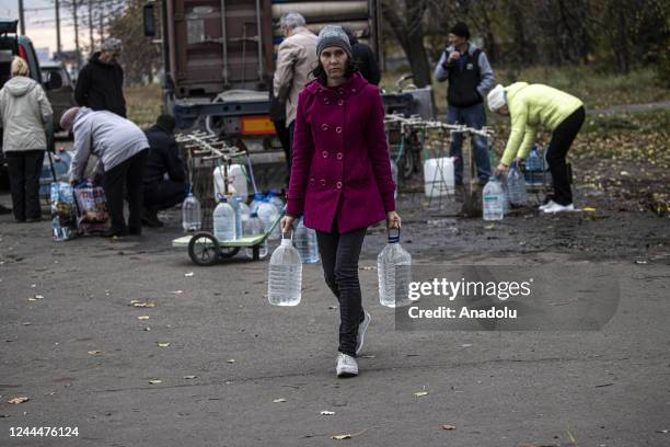 Ukrainian citizens carry bottles and buckets to receive clean water as Russia-Ukraine war continue in Mykolaiv, Ukraine on November 03, 2022. Water...