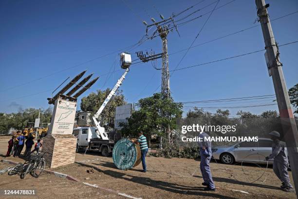 Palestinians inspect power lines damaged during an early morning Israeli air strike in the Maghazi refugee camp in the central Gaza Strip, on...