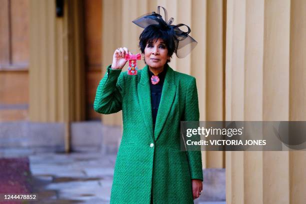 British television presenter Moira Stuart poses with her medal after being appointed a Commander of the Order of the British Empire for services to...