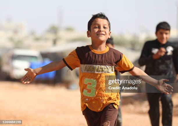 Refugee child smiles at a tent city in Idlib, Syria on October 25, 2022.