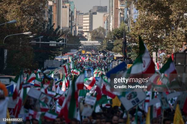Iranian people carrying Iran flags while attending a gathering out of the former U.S. Embassy in Tehran to mark the anniversary of the seizure of the...