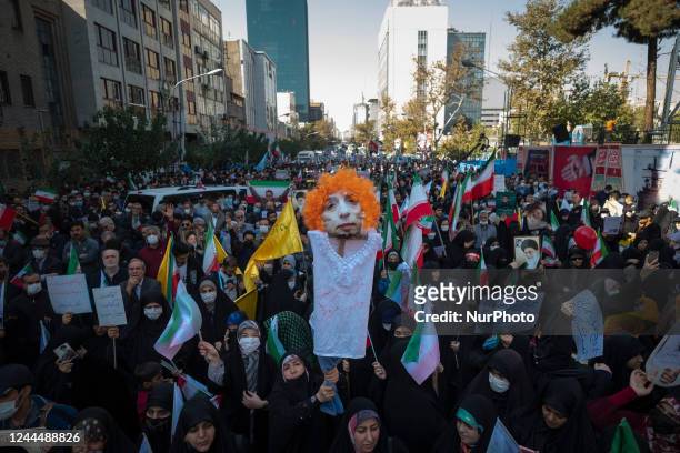 Veiled Iranian woman holds an effigy of Iranian journalist, Masih Alinejad, during a gathering out of the former U.S. Embassy in Tehran to mark the...
