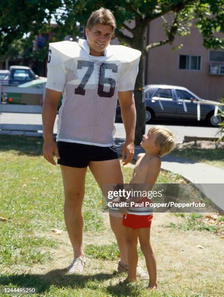 Los Angeles Raiders offensive tackle Ed Muransky with a young boy, circa 1984.