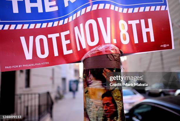 Sticker for Indigenous Person's Day affixes to a street post below a placard stating "VOTE NOV. 8TH" on November 4, 2022 in Philadelphia,...