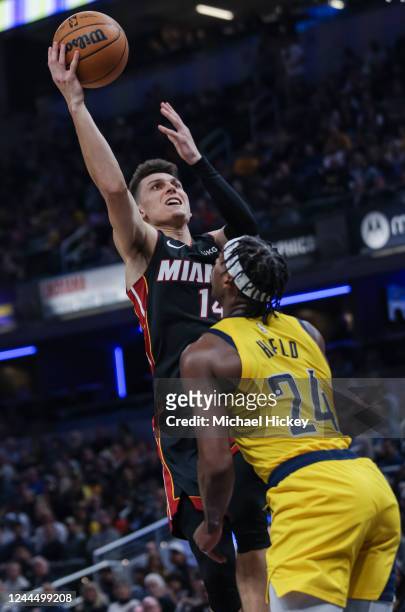 Tyler Herro of the Miami Heat shoots the ball against Buddy Hield of the Indiana Pacers during the first half of the game at Gainbridge Fieldhouse on...