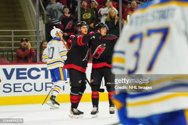Sebastian Aho of the Carolina Hurricanes scores a goal and celebrates with teammate Seth Jarvis during the first period of an NHL game against the...